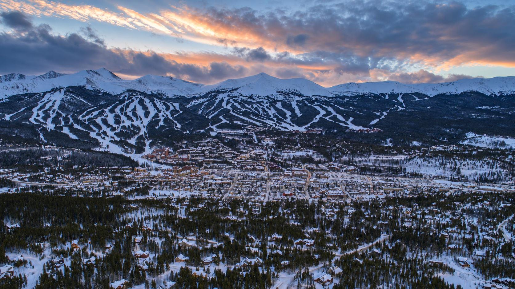 Breckenridge mountain peaks and ski runs beneath a natural winter sunset